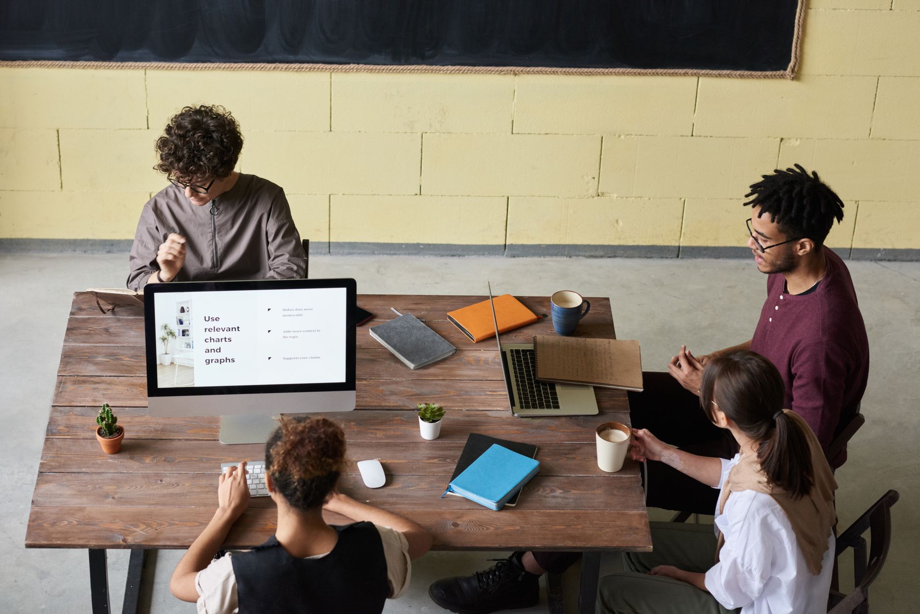 Colleagues working together around laptops in a bright office.